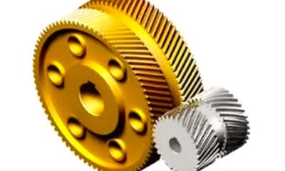 A five-axis CNC machine tool is performing high-precision helical gear machining, showcasing a modern automated manufacturing environment.